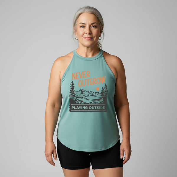 Woman wearing an old lady gains eucalyptus halter tank top with a graphic that reads never outgrow playing outside