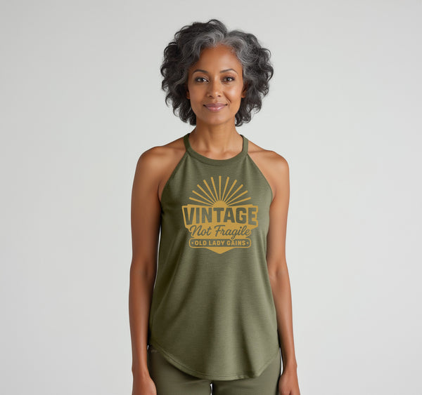 Woman with grey streaked hair wearing a green vintage not fragile halter tank top