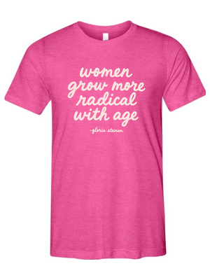 A heather pink short-sleeve t-shirt with white script text reading 'women grow more radical with age -gloria strauss' on the front, displayed against a solid white background.
