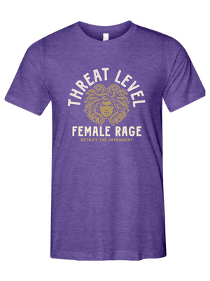 Purple t-shirt with graphic design of medusa and says threat level female rage petrify the patriarchy on a white background