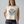 Faded cream cropped muscle tank with a blue and orange butterfly graphic and Dolly Parton quote 
