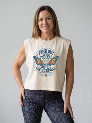 Faded cream cropped muscle tank with a blue and orange butterfly graphic and Dolly Parton quote "Find out who you are and do it on purpose"