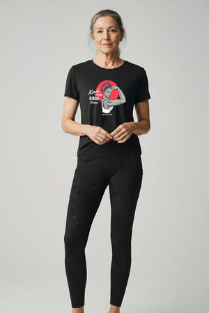 Confident woman in her 70s wearing black leopard constantly varied gear leggingsin and Kinda Vintage Kinda Savage Rosie unisex triblend t-shirt in black. 