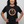 A muscular, active middle-aged woman wearing a heather charcoal black triblend unisex t-shirt. The graphic features a retro, circular ranger bear design pointing forward and holding a barbell, with bold red and cream text that reads: REMEMBER Only You Can Age Strong.