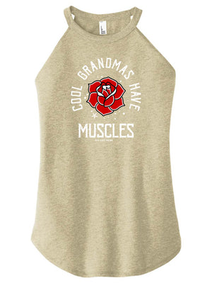 A woman wearing a tan high-neck halter tank top with text and a graphic on it.