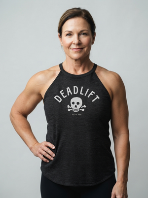 A woman modeling a dark charcoal gray heathered tank top with a white graphic that reads 'DEADLIFT' above a skull and crossbones, set against a solid light gray background.