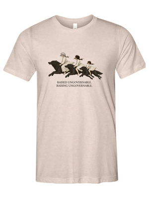 A light beige crewneck t-shirt featuring a vintage-style graphic of three women riding horses, with the text 'RAISED UNGOVERNABLE. RAISING UNGOVERNABLE.