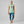 Woman wearing a mint-green muscle tank with a retro Rosie-style graphic that reads Kinda Vintage Kinda Savage.