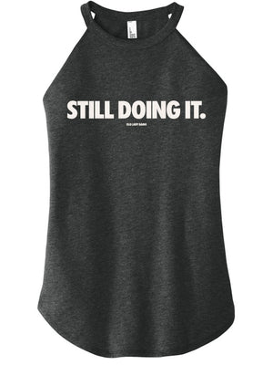 Black tank top with 'STILL DOING IT.' text on a white background