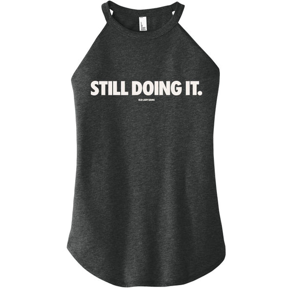 Black tank top with 'STILL DOING IT.' text on a white background