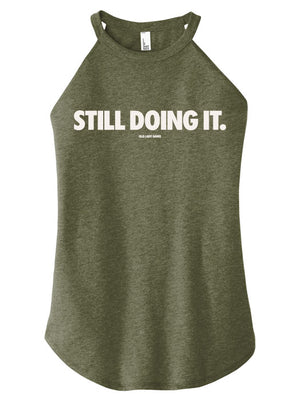 Green tank top with 'STILL DOING IT.' text on a white background