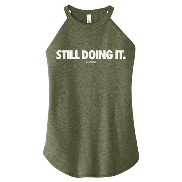 Green tank top with 'STILL DOING IT.' text on a white background