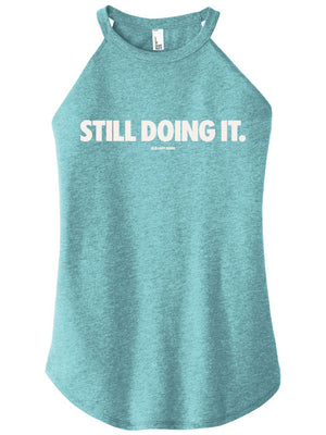 Teal tank top with 'STILL DOING IT.' text on a white background