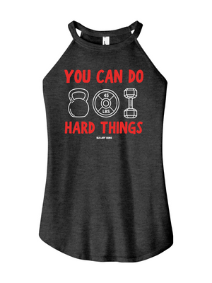 A women's heather black halter tank top featuring a red and white graphic print on the front that reads 'YOU CAN DO HARD THINGS' with kettlebell, weight plate, and dumbbell illustrations.