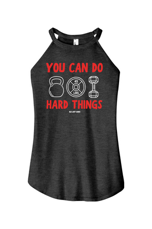 A women's heather black halter tank top featuring a red and white graphic print on the front that reads 'YOU CAN DO HARD THINGS' with kettlebell, weight plate, and dumbbell illustrations.