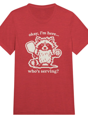 Funny pickleball graphic featuring a raccoon holding a paddle and pickleball with the text “Okay, I’m Here… Who’s Serving?”