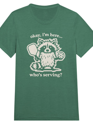 Funny pickleball graphic featuring a raccoon holding a paddle and pickleball with the text “Okay, I’m Here… Who’s Serving?”