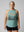 Woman wearing an old lady gains eucalyptus halter tank top with a graphic that reads never outgrow playing outside