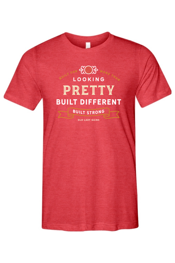 Woman's red t-shirt reading "Built for More Than Looking Pretty. Built Different. Built Strong." by Old Lady Gains, motivational fitness apparel for women over 40.