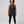 middle aged woman wearing a black tank halter tank top with a graphic design of historic woman harriet tubman deadlifting