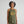 Woman with grey streaked hair wearing a green vintage not fragile halter tank top 
