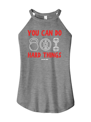 A heather gray racerback tank top featuring a red and white graphic print that reads 'YOU CAN DO HARD THINGS' with kettlebell, weight plate, and dumbbell illustrations.